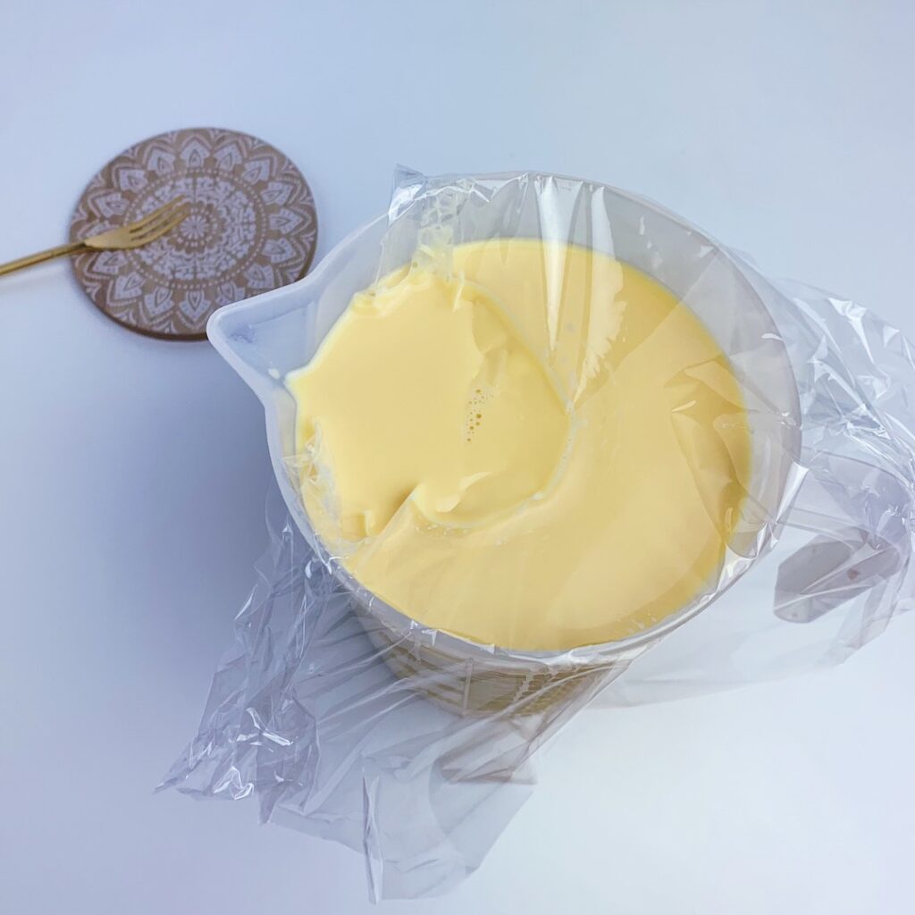 將保鮮膜蓋在布丁液上，過濾氣泡