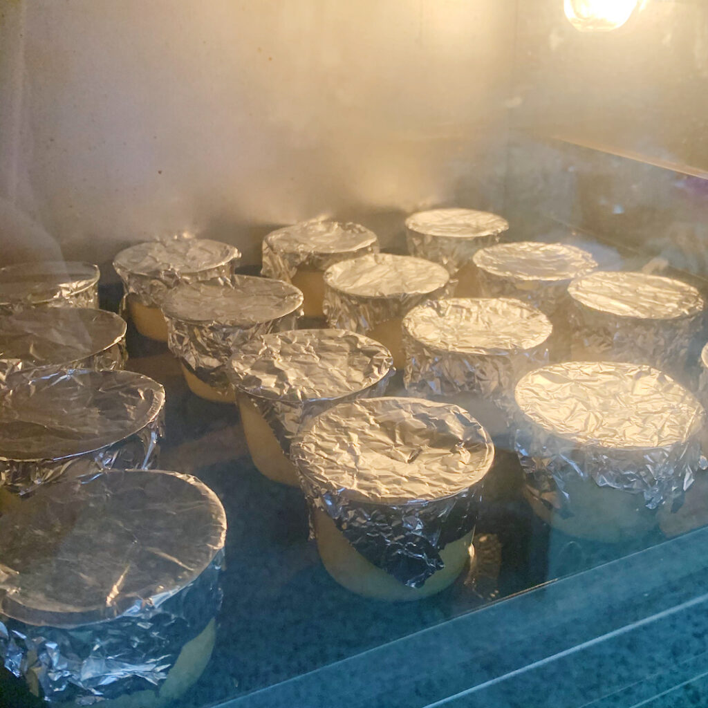 將每個布丁都蓋上錫箔紙，然後放入烤箱烘烤
